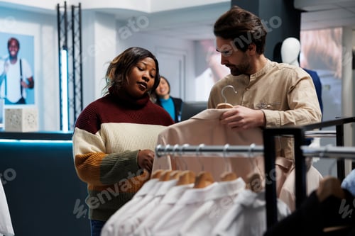 Preview: Store assistant showing jacket to woman