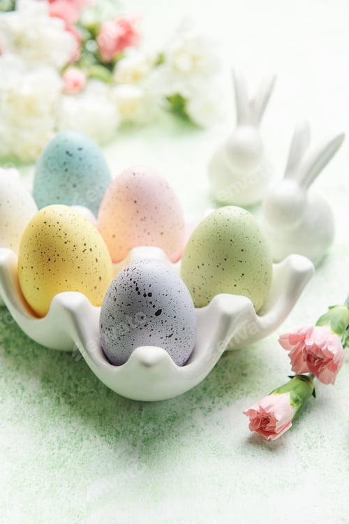 Preview: Easter decor. Colored Easter eggs on a ceramic stand and decorative rabbits.
