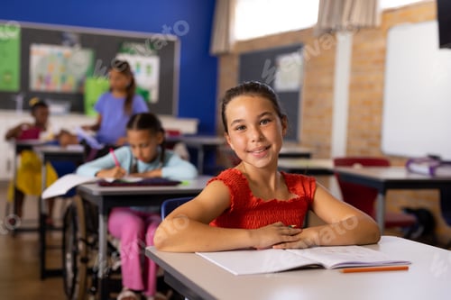 Visualização: Retrato de alunas felizes, diversas e deficientes em cadeira de rodas, escrevendo em sala de aula