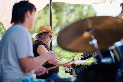 Preview: Rock band performing at outdoor venue on sunny day with lively atmosphere