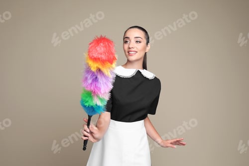 Preview: Young chambermaid with dusting brush on color background