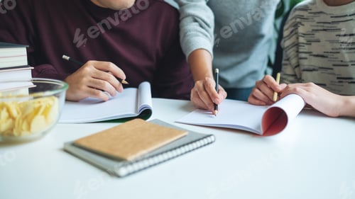 Preview: Group of young students tutoring and catching up workbook with friends