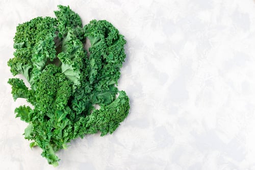 Preview: Kale leaves on gray background, top view, horizontal, copy space
