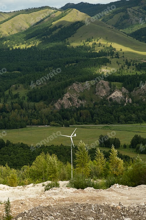 Preview: Small wind turbine generating clean, renewable energy in lush green valley with rolling hills