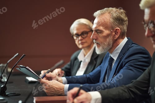 Preview: Middle Aged Caucasian Man Reviewing Documents during Political Meeting