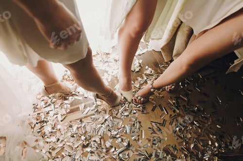 Preview: Sexy Girl legs in stylish white shoes, standing on gold and silver confetti