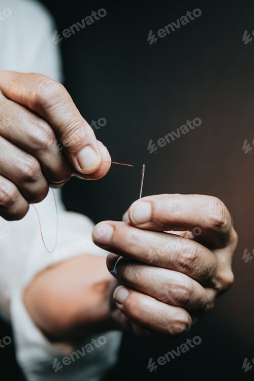 Preview: Close up on woman's hands sewing needle and thread. Old woman working wasted hands