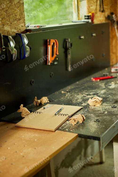Preview: Carpenter workplace with notepad and power working tools graver for wooden utensils spoon