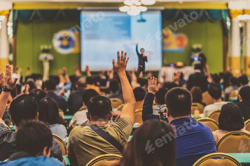 Preview: Rear view of Audience showing hand to answer the question from Speaker on the stage