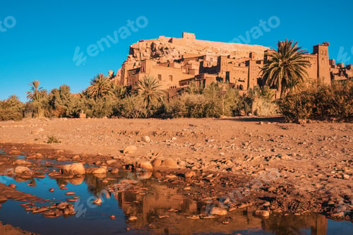 Preview: Ancient stone buildings near palms and water