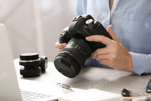 Preview: Journalist with camera working at table, closeup