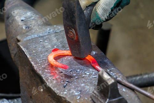 Preview: blacksmith in the workshop making horseshoes