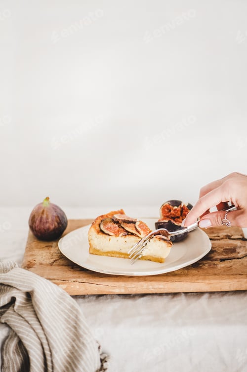 Preview: Hand of woman eating homemade gluten free fig cheesecake
