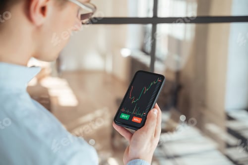 Preview: Cropped rare view of guy checking bitcoin price chart on digital stock exchange app on phone