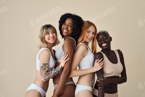 Preview: 4 happy diverse young girls in underwear hugging isolated on beige background.