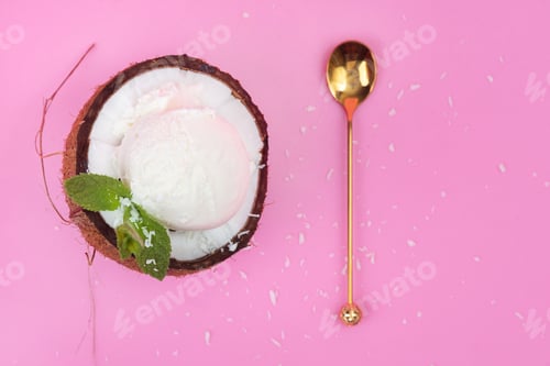 Preview: Vanilla ice cream balls in a fresh coconut half decorated with mint leaves with a spoon on a pink