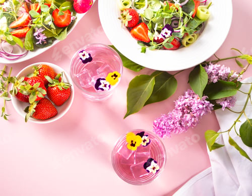 Preview: purple cocktail decorated flowers viola pansies, salad with edible flowers and strawberries.