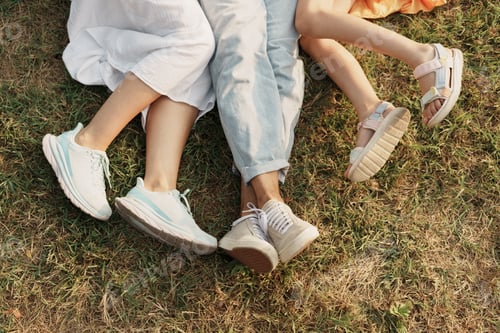 Preview: Family bonding time on grass with legs and shoes visible