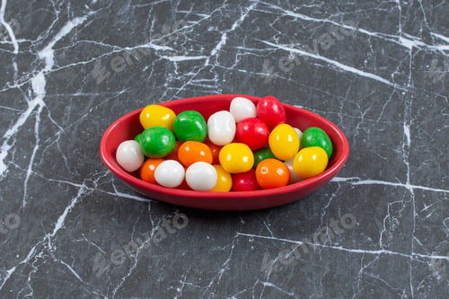 Preview: Pile of colorful candies in red bowl