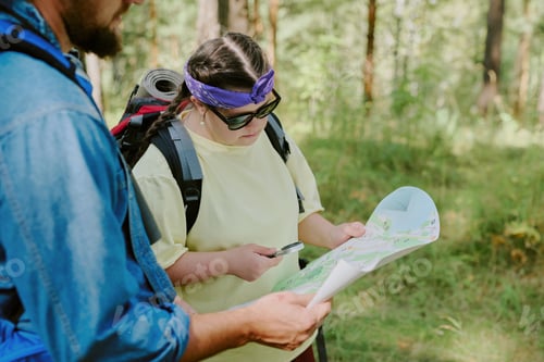 Preview: Teenage Girl Navigating Forest Trail with Map and Smartphone