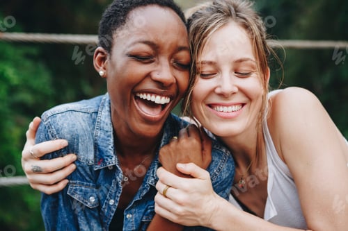 Preview: Happy black woman laughing with her friend