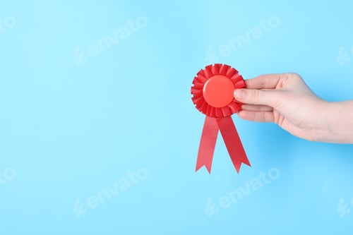 Preview: Woman holding red award ribbon on light blue background, closeup. Space for text