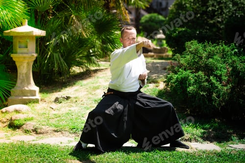 Preview: Young serious man aikido master in traditional costume