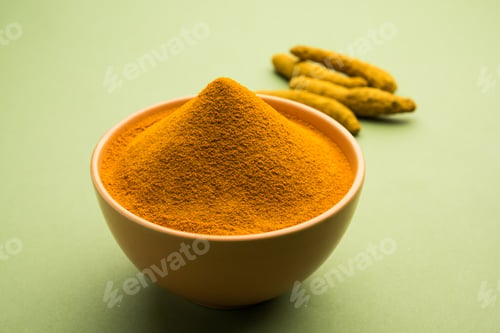 Preview: Organic Haldi or Turmeric powder spice pile in a bowl with whole, selective focus