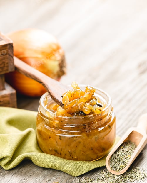 Preview: Onion jam in a glass jar on a wooden table