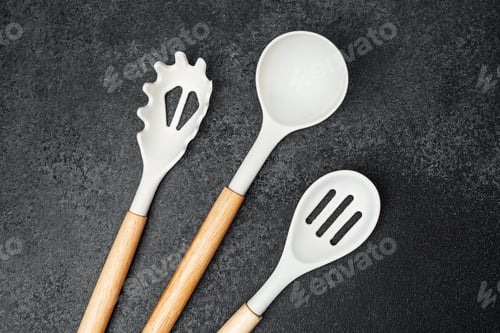 Preview: Elegant cooking utensils arranged on a dark background for culinary inspiration