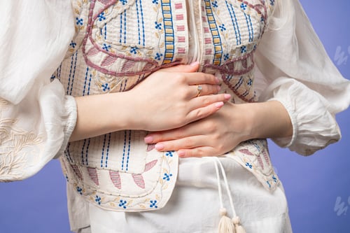 Preview: Young woman squeezing belly with hands. abdominal pain, suffering stomach ache