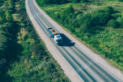 Preview: Aerial drone view of dump truck with sand driving on asphalt road along summer landscape.