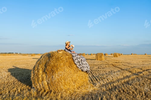 Preview: Happy girl on field of wheat with bread