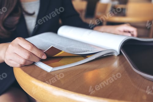 Preview: Closeup image of a business woman reading a book in modern cafe