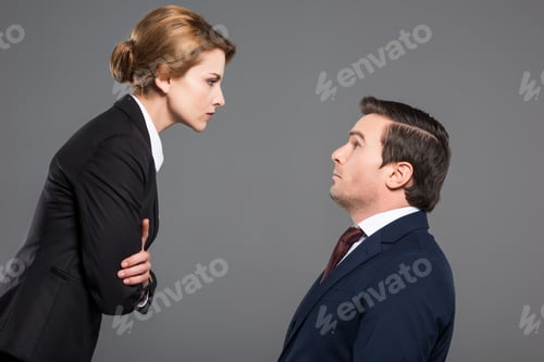 Preview: angry female boss looking at scared businessman, isolated on grey, feminism concept