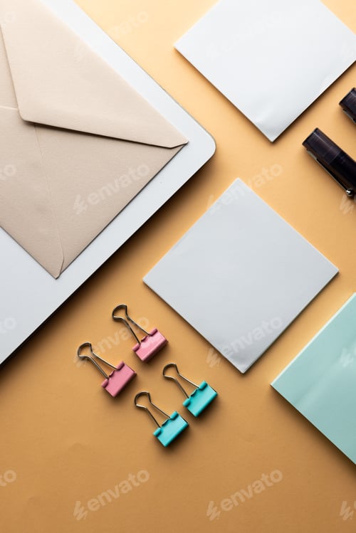 Preview: Flat lay of black pens, envelope, paper clips and memo notes with copy space on yellow background