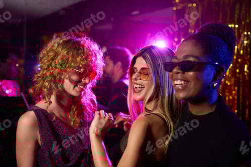 Preview: Happy multi-ethnic girlfriends dancing and enjoying night party at disco club