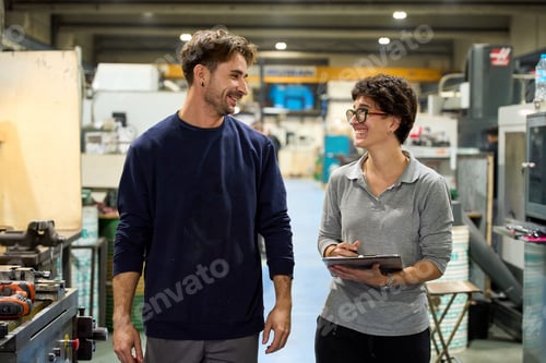Preview: Smiling workers walking and talking in a factory