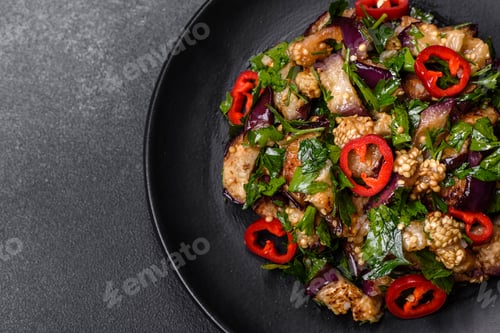 Preview: A salad of baked aubergine, sweet pepper, garlic, zucchini and parsley in a black plate