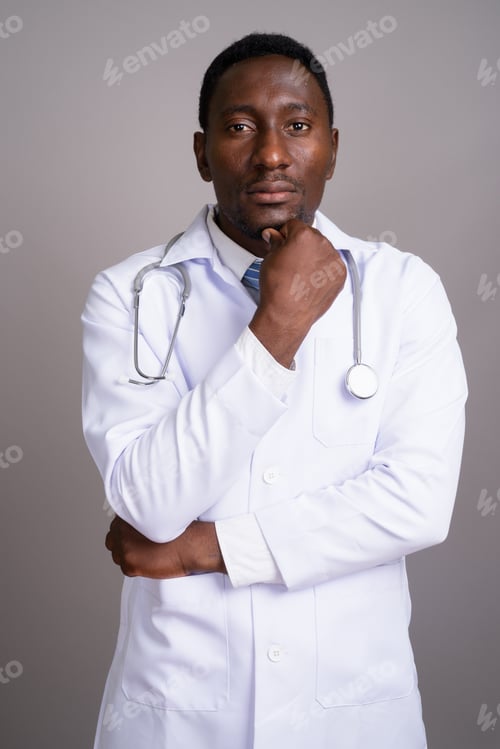 Preview: Young handsome African man doctor against gray background