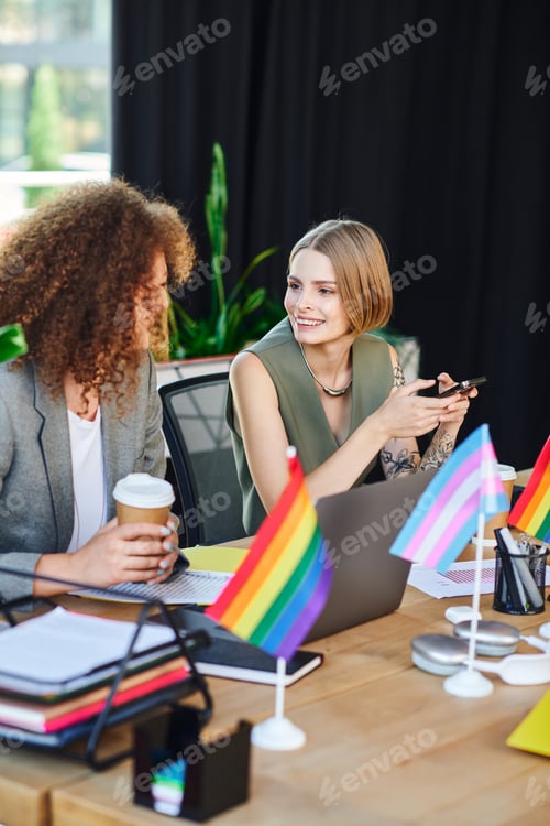 Preview: Coworkers in a vibrant office share laughter and ideas while supporting the LGBTQ community