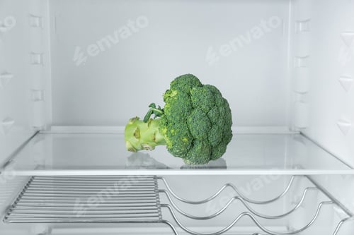 Preview: Fresh organic broccoli on empty shelf in refrigerator