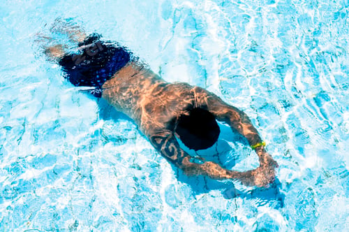 Preview: Adult male swimming underwater in an outdoor swimming pool.