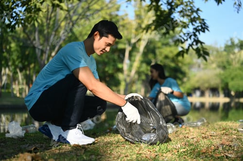 Preview: Male volunteer collecting garbage at the public park. Collaboration, charity and recycling concept