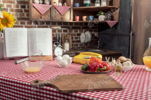 Preview: various uncooked products and recipe book on cooking table at kitchen