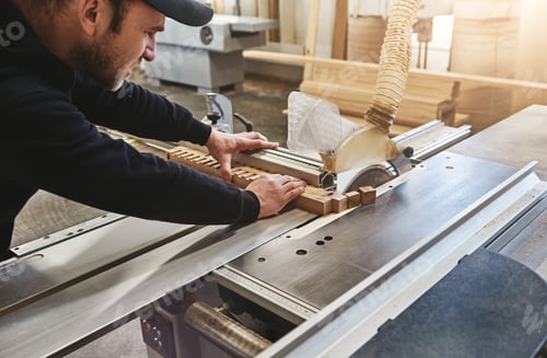 Preview: No one does woodworking like us. Close up of carpenter working with industrial tool in wood factory