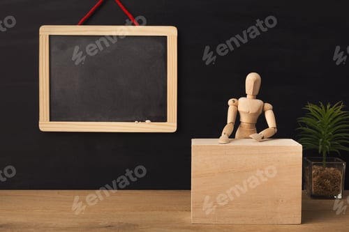 Preview: Wooden marionette sitting in classroom