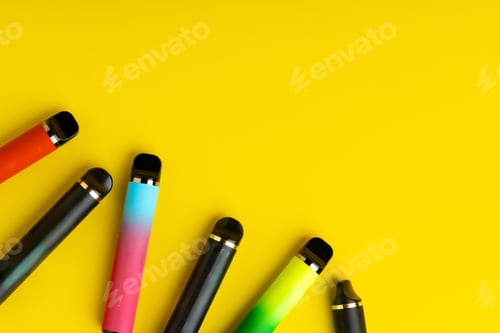 Preview: Colorful disposable electronic cigarettes on yellow background
