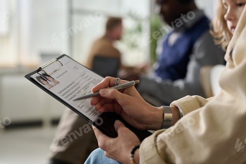 Preview: Close up of young woman filling application form