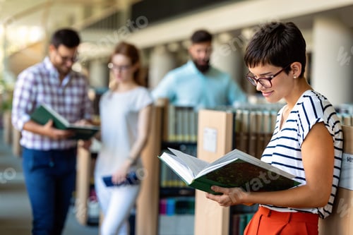 Preview: Happy group of students studying and working together in a college library